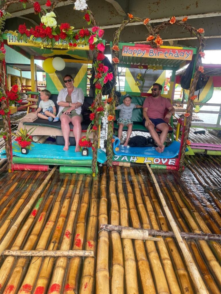 Family enjoying the Great River Rafting Tour on a bamboo raft in Hanover, Jamaica.